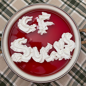 A bowl of red JELL-O with the words "CF sucks" written on it in whipped cream