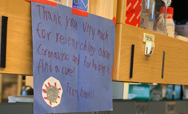 Handwritten sign from a child thanking doctors for their research for COVID-19.