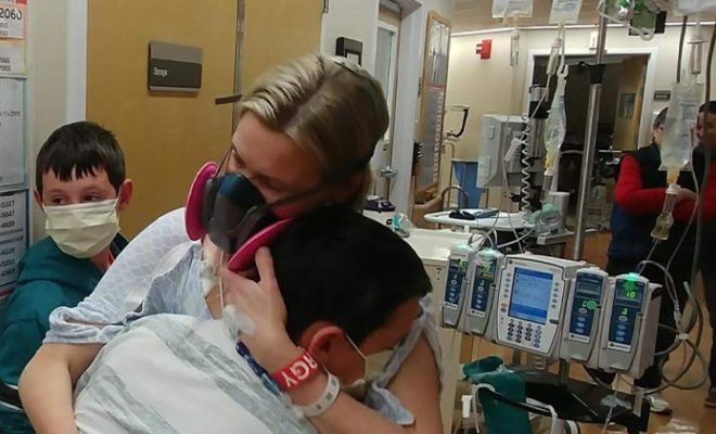 Larissa in a hospital gown hugging her son after her lung transplant.
