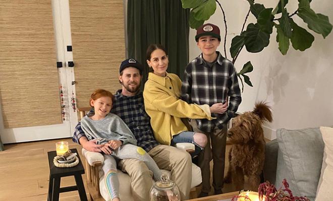 Lauren Molasky sitting down on the couch with her husband, two children, and dog.
