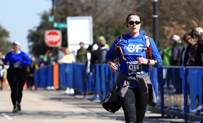 Jennifer Riley crossing the finish line at the marathon.