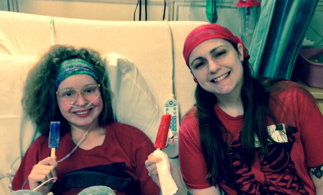 Judy in a hospital bed smiling with Lacey eating popsicles. 