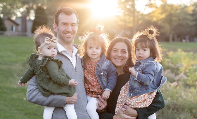 Christin smiling with her husband and three young girls.