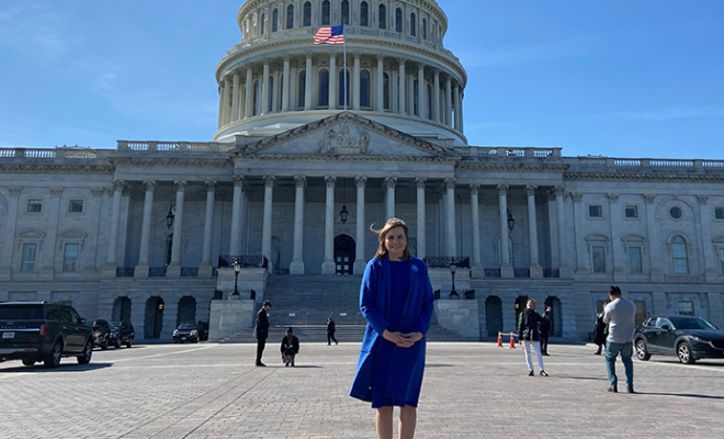 Crystal standing outside the Capitol wearing a blue coat.