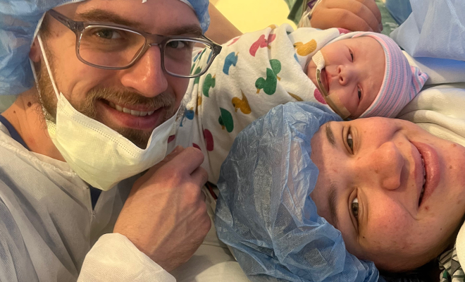 Shellie, her husband, and her newborn baby smiling together immediately after her C-section
