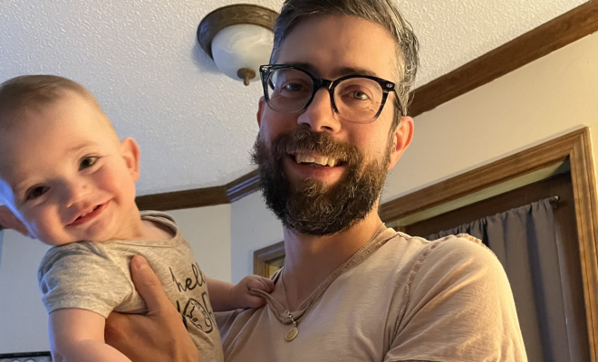 Jessi's fiance smiling and holding their son, Oliver, who has CF