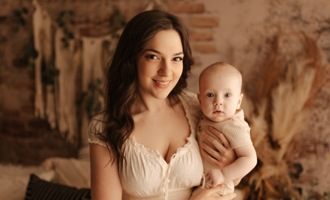 Carolanne holding her baby, Bellamy, and smiling at the camera during a family photoshoot. 