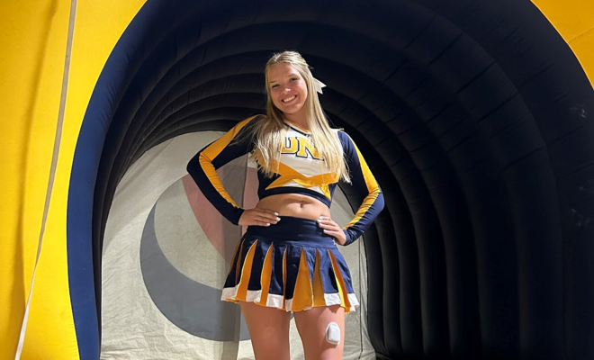 Kelcee posing and smiling in her cheerleading uniform