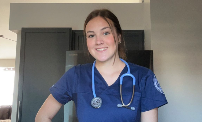 Annaka Haynes smiling and wearing blue scrubs with a stethoscope around her neck 