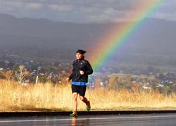Tommy Danger runs with a rainbow behind him. 